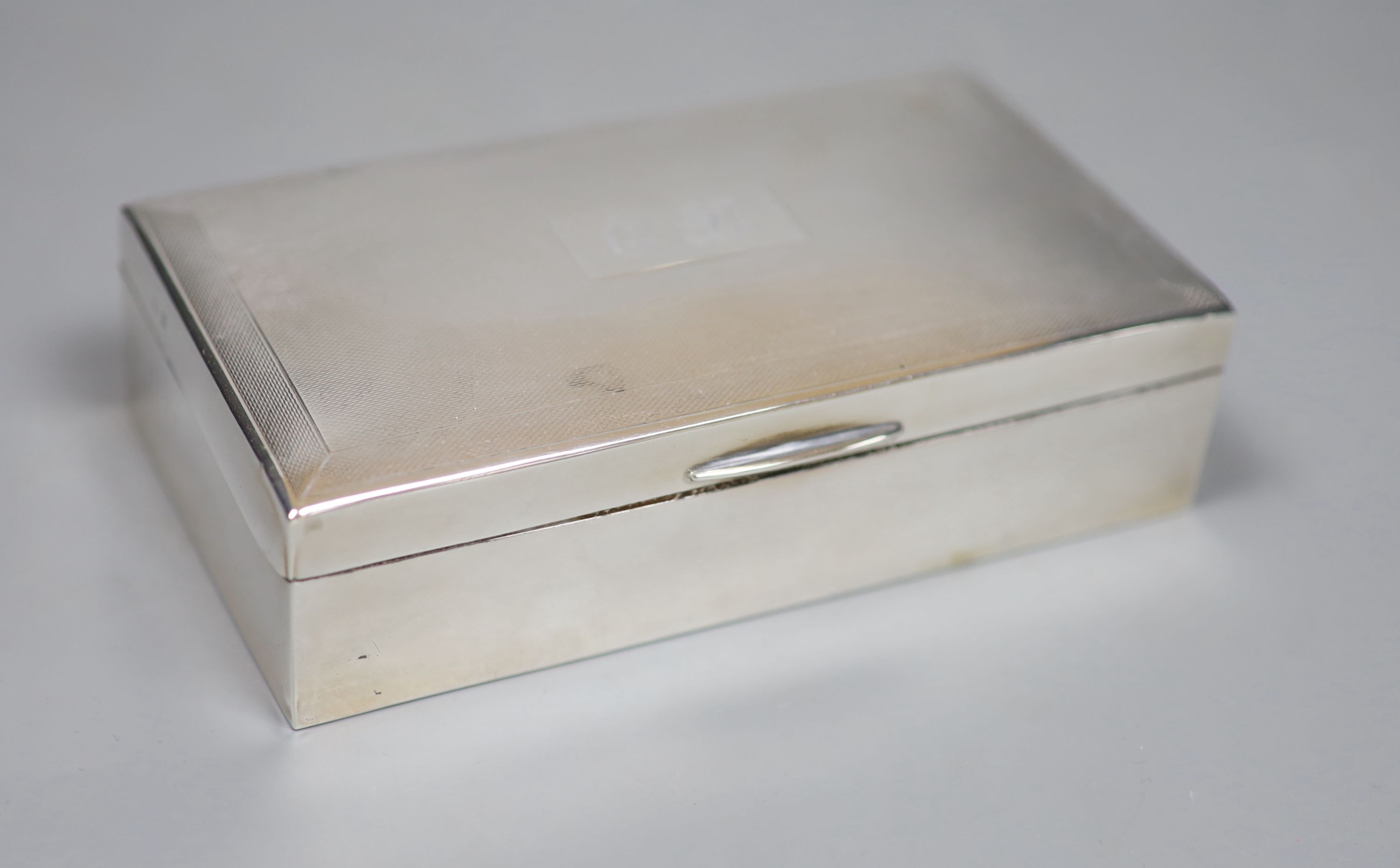 A 1960s engine turned silver mounted rectangular cigarette box, with engraved initials, 15.9cm, gross 14.5oz.